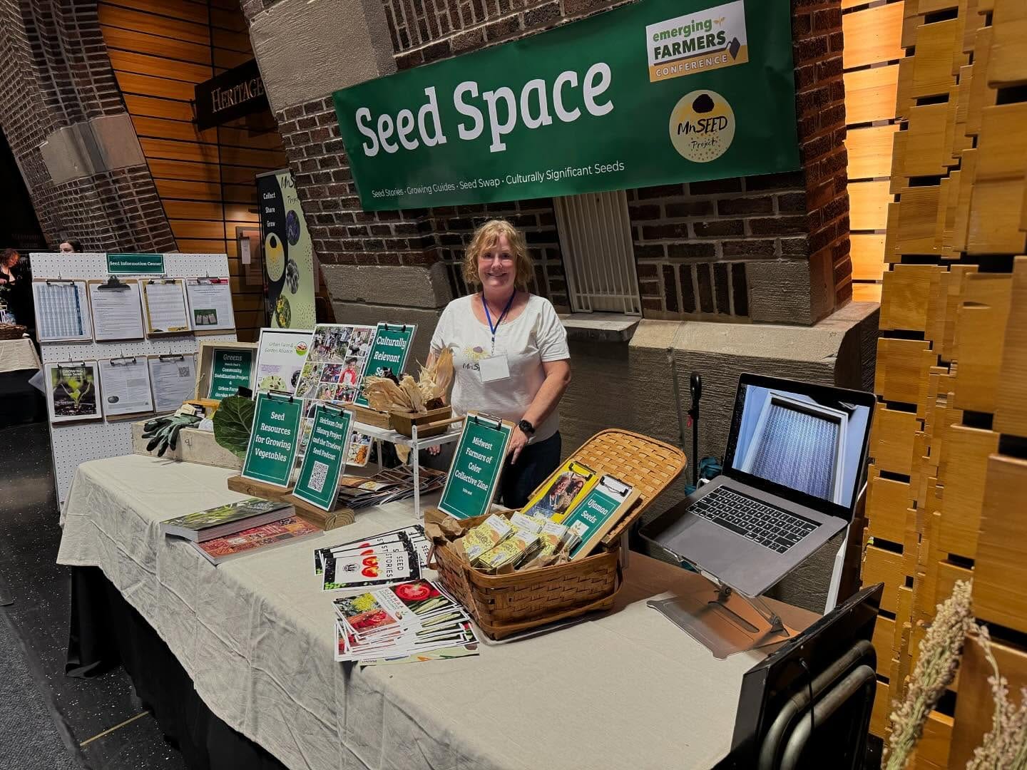 A person standing behind a table displaying information about seed saving