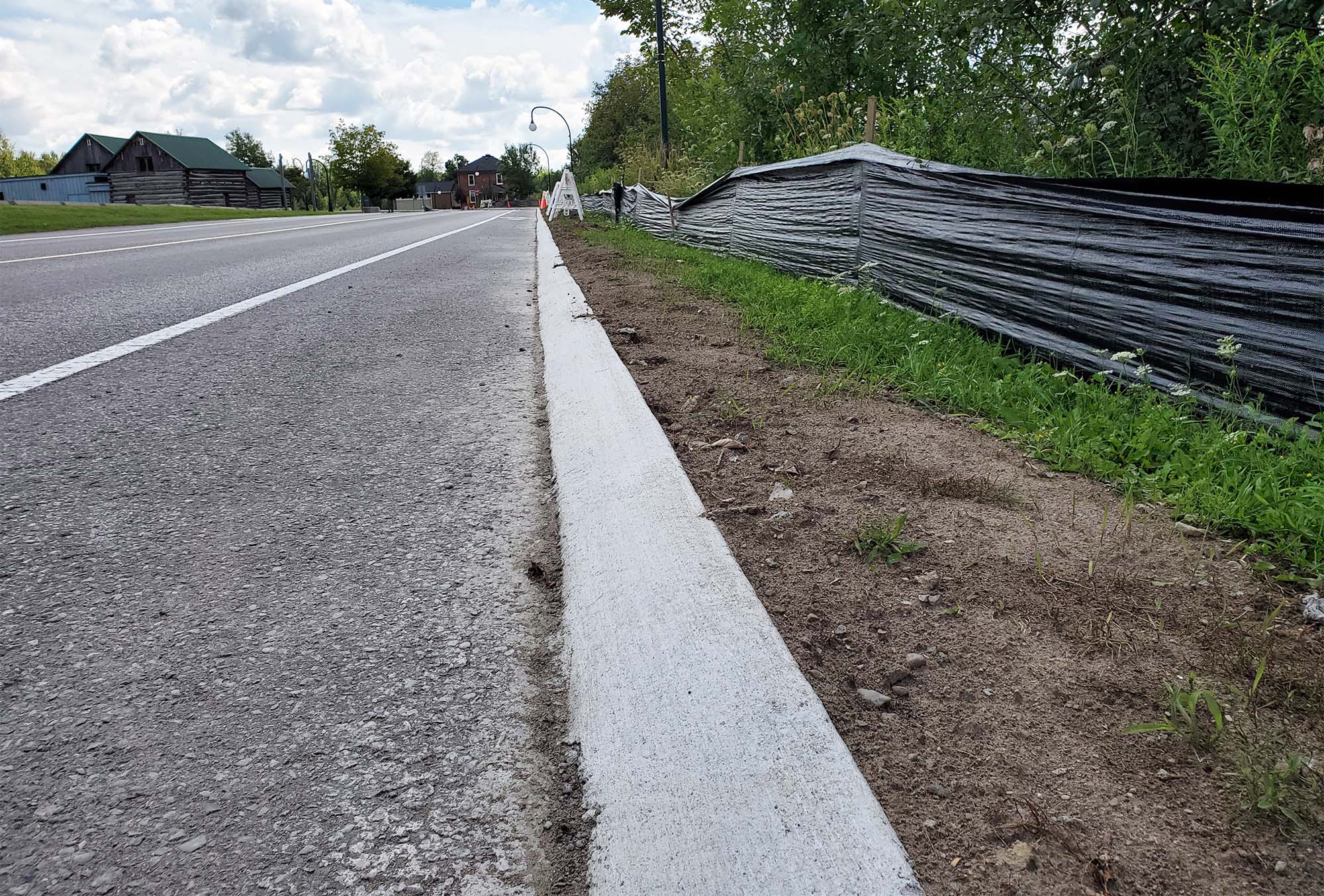 A roadside curb that is sloped rather than vertical